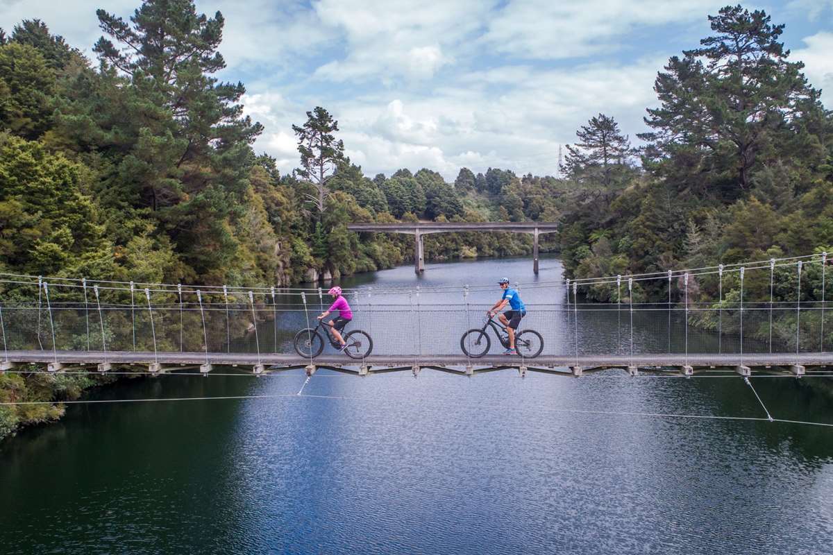 Waikato River Trails couple biking on a bridge - Waikato River
