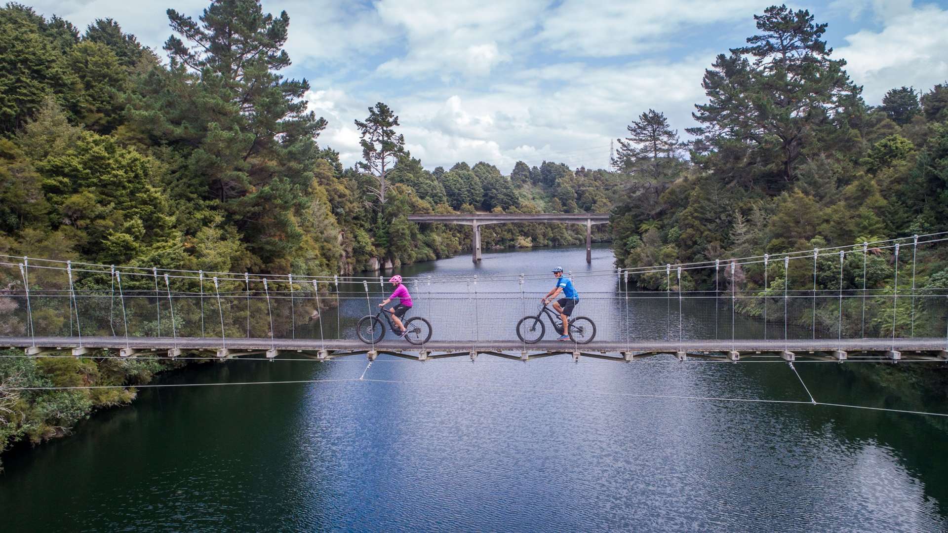 Waikato River Trails couple biking on a bridge - Waikato River