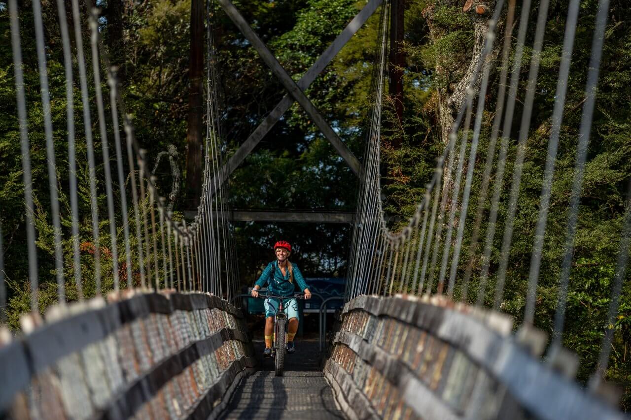 Woman riding a bridge in Tongariro River Trail, Turangi