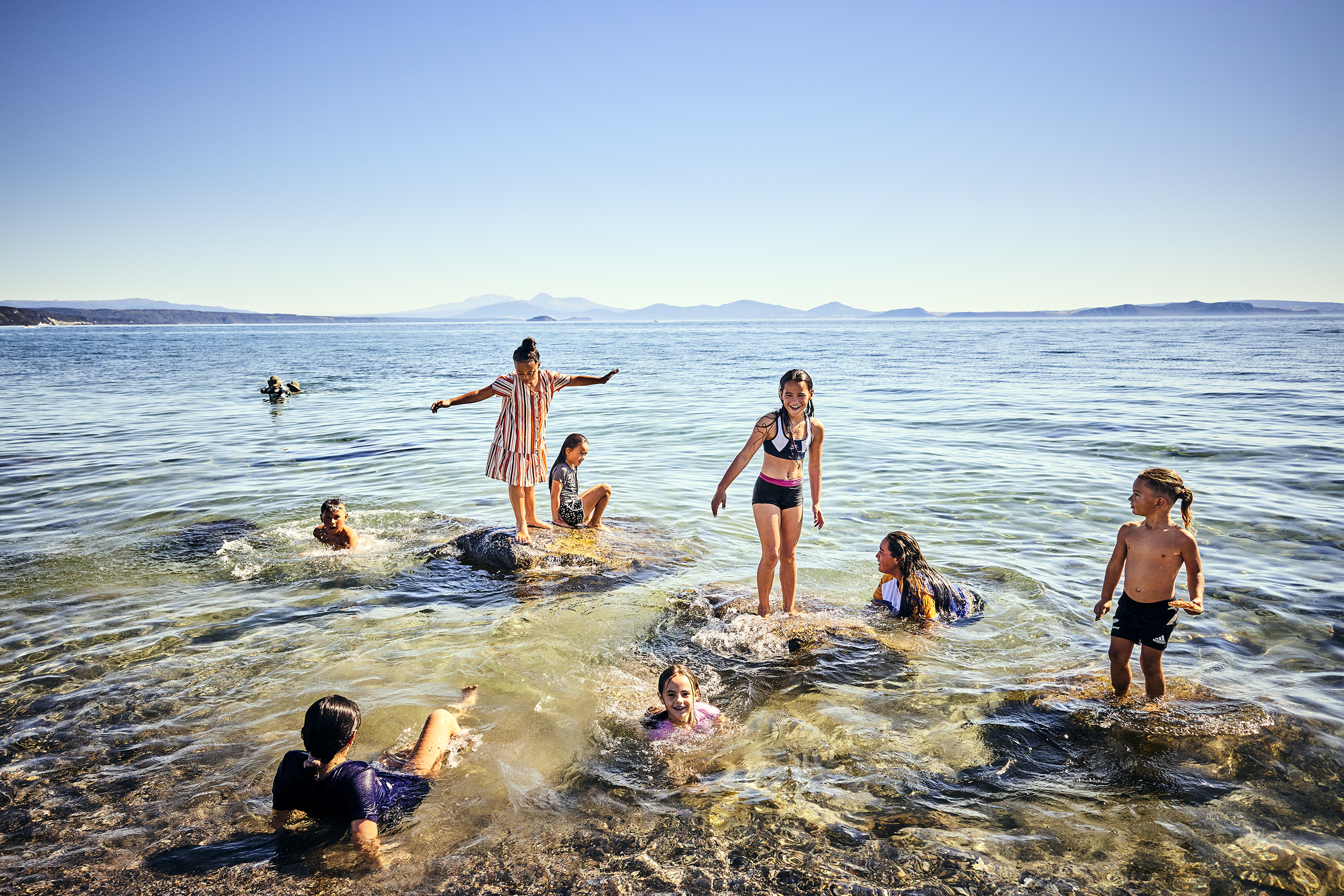 Lake Taupo Wharewaka - mountains, kids playing in the lake - photo by Todd Eyre